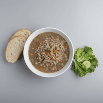 A stark, professional photograph of German-style barley soup in a plain white bowl, set against a neutral background. Beside the soup are two slices of plain crusty bread and a small bowl with a simple green salad, all under bright, clinical lighting to create a clean and boring aesthetic.